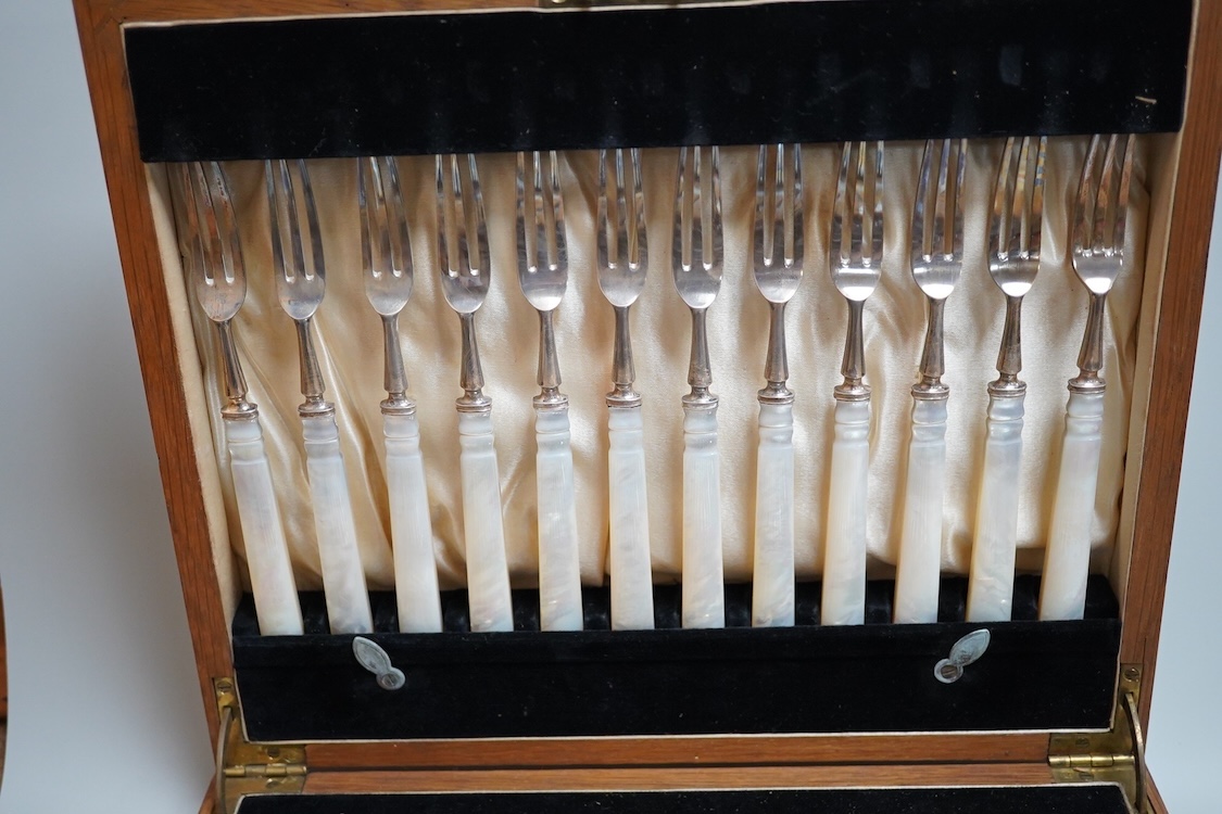A set of twelve pairs of George V mother of pearl handled silver dessert eaters, by Roberts & Belk, Sheffield, 1926, knife 19.3cm, in a fitted oak box.